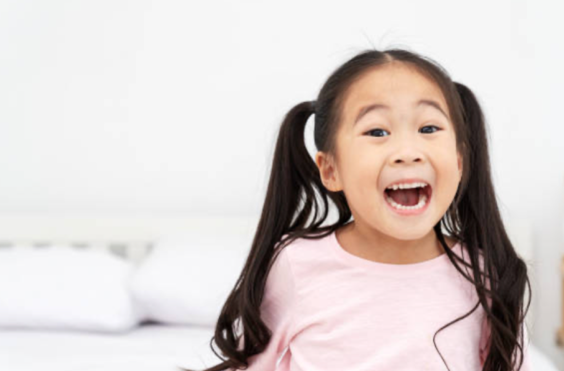 excited little girl smiles at the camera